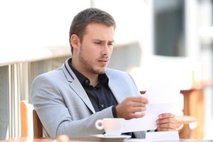 Worried man looking at wrong amount of debt collection