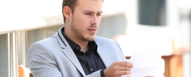 Worried man looking at wrong amount of debt collection